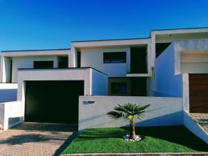 uma casa branca com uma palmeira em frente em Casa do Golfe by VinteOito em Amarante