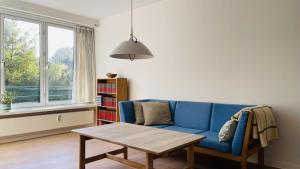 a living room with a blue couch and a table at ApartmentInCopenhagen Apartment 1517 in Copenhagen