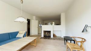 salon z niebieską kanapą i kominkiem w obiekcie ApartmentInCopenhagen Apartment 1517 w Kopenhadze
