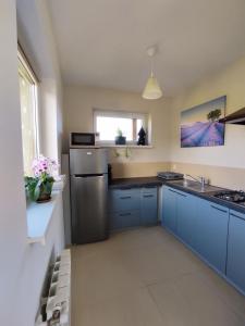 a kitchen with blue cabinets and a stainless steel refrigerator at Sielski Domek pod Karpaczem in Miłków