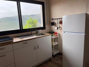 cocina con nevera blanca y ventana en Casa La Cabezada en San Sebastián de la Gomera