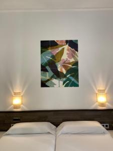 サン・セバスティアンにあるペンション ドノスティアラのベッド2台 壁にランプ2つが備わる客室です。