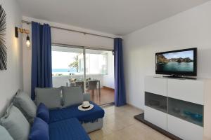 uma sala de estar com um sofá azul e uma televisão em Apartment Aida 202 by VillaGranCanaria em Playa del Inglés