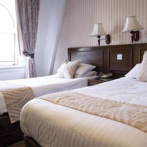 a hotel room with two beds and a window at Durrant House Hotel in Bideford