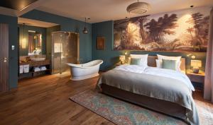 ein Schlafzimmer mit einem großen Bett und einer Badewanne sowie ein Badezimmer in der Unterkunft Vabali Spa Hamburg Hotel in Glinde
