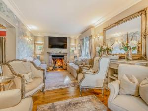 a living room with white furniture and a fireplace at Willington Lodge in Hanmer