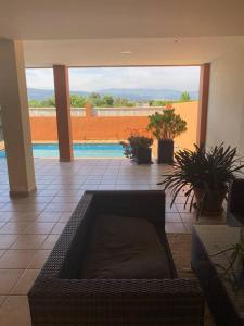 ein Wohnzimmer mit einem Sofa und einem Pool in der Unterkunft Apartamento con piscina en Alicante, Beniarbeig in Beniarbeig
