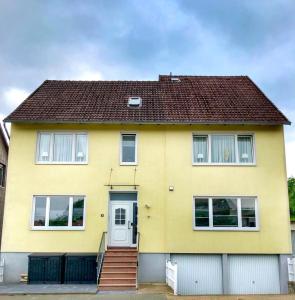uma casa amarela com um telhado castanho em Ferienwohnung Busch em Bad Sachsa
