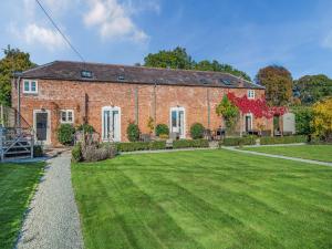a brick house with a large lawn in front of it at Willington Lodge in Hanmer