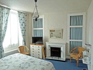 a bedroom with a bed and a fireplace at Maison de Fortitude Chambres d'hotes in Salviac