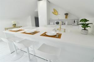- une cuisine blanche avec une table blanche et des assiettes dans l'établissement L'Or Blanc centre calme -15km d'Étretat, à Fécamp