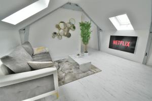 sala de estar con sofá y TV en L'Or Blanc centre calme -15km d'Étretat, en Fécamp