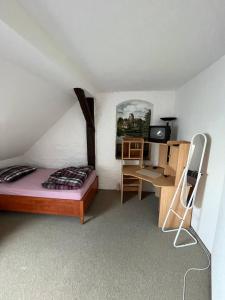 a bedroom with a bed and a desk and a chair at Pension für Monteure in Leisnig in Leisnig