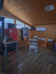 a room with a table and chairs and a video game at Mökki ja rantasauna Saimaan rannalla in Taipalsaari