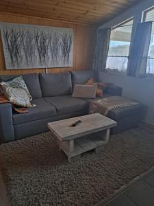 a living room with a blue couch and a coffee table at Mökki ja rantasauna Saimaan rannalla in Taipalsaari