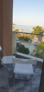 a balcony with two chairs and a view of a parking lot at GreenCity Kavala in Kavála