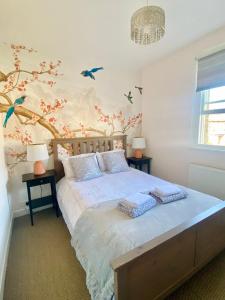 a bedroom with a bed with birds on the wall at Delightful 2 Bedroom House Central Windsor in Windsor