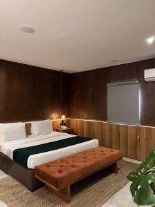 a bedroom with a large bed and a brown couch at The Borough Lagos in Lagos