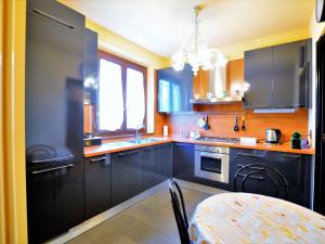 una cocina con armarios negros y una mesa. en Attractive villa in Marsciano Perugia with a pool, en Marsciano