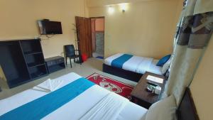 una camera d'albergo con due letti e una televisione di Golden Lake a Pokhara