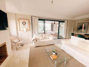 a living room with a white couch and a table at Sotogrande Alboaire- Waterfront luxury 4 bedroom Apt in the Marina of Sotogrande in Sotogrande