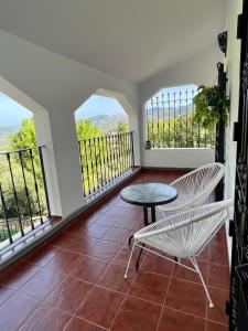 balcón con mesa, sillas y ventanas en NOVIEMBRE La Iruela, en La Iruela