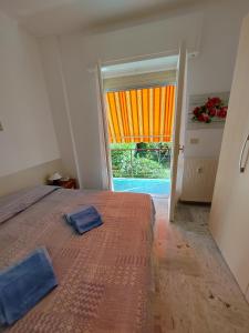 una camera con un letto e una porta con una tenda arancione di Casa Serena a Bordighera