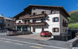 mały czerwony samochód zaparkowany przed budynkiem w obiekcie Casa San Marco n 8 w Livigno