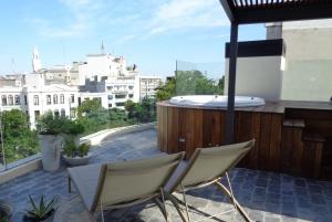 balkon z 2 krzesłami i wanną z hydromasażem w budynku w obiekcie Alma Histórica Boutique Hotel w mieście Montevideo