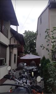 a group of motorcycles parked outside a building with an umbrella at Camere Centrale in Piteşti