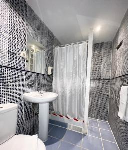 een badkamer met een toilet, een wastafel en een douche bij Hostal La Casa de La Plaza in Madrid