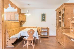 een keuken met houten kasten en een tafel en stoelen bij Casa Loretta in Alba di Canazei