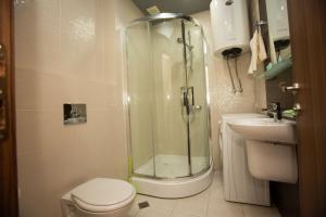 a bathroom with a shower and a toilet and a sink at Royal Apartments Batumi in Batumi