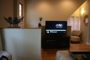 a living room with a flat screen tv on a stand at Roscoe Village Guesthouse in Chicago