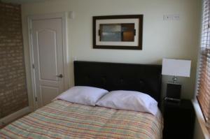 een slaapkamer met een bed en een foto aan de muur bij Roscoe Village Guesthouse in Chicago