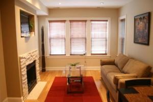 a living room with a couch and a fireplace at Roscoe Village Guesthouse in Chicago