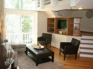 a living room with chairs and a table and a tv at Roscoe Village Guesthouse in Chicago