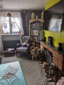 a living room with a fireplace and a chair at Quiet Quaint & Quirky House Colchester Town Centre in Colchester