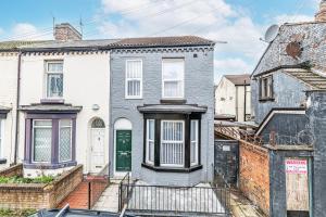 a gray house with a green door on a street at 3 Bedroom Holiday Home Liverpool in Liverpool