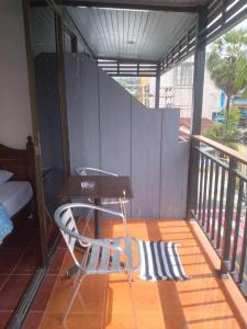 a patio with a table and a chair on a balcony at Kamala bay inn in Kamala Beach