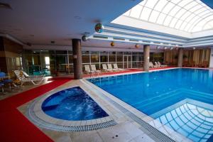 a large swimming pool in a hotel with a skylight at Grand Hotel Victory in Aktau