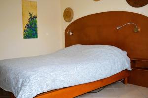 a bed with a wooden headboard in a bedroom at Le Break - maison de plain-pied avec jardin in Courseulles-sur-Mer