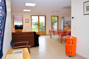 salon z kanapą, stołem i krzesłami w obiekcie Le Break - maison de plain-pied avec jardin w mieście Courseulles-sur-Mer