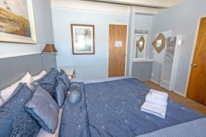 Un dormitorio con una cama con sábanas y almohadas azules. en Ala Wai BoulevardApartment 23, en Lake Valley