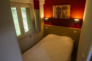 mały pokój z łóżkiem w pokoju z oknem w obiekcie VVF Saint-Lary-Soulan Hautes-Pyrénées w mieście Saint-Lary-Soulan