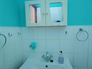 baño con lavabo e iluminación azul en Cozy Blue Guesthouse, en East London