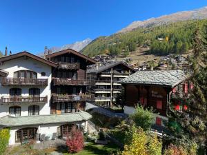 um grupo de edifícios com montanhas ao fundo em Chalet Medi em Zermatt