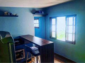 Habitación azul con escritorio de madera y ventana en Cabana Solitude - Concha, en Florianópolis 17 fotos más