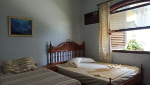 - une chambre avec 2 lits jumeaux et une fenêtre dans l'établissement Pousada Praia Sol do Indaiá, à Bertioga