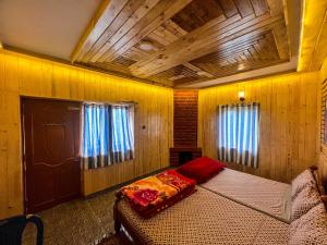 a bedroom with a bed in a room with wooden walls at Venish Home Stay in Kodaikānāl